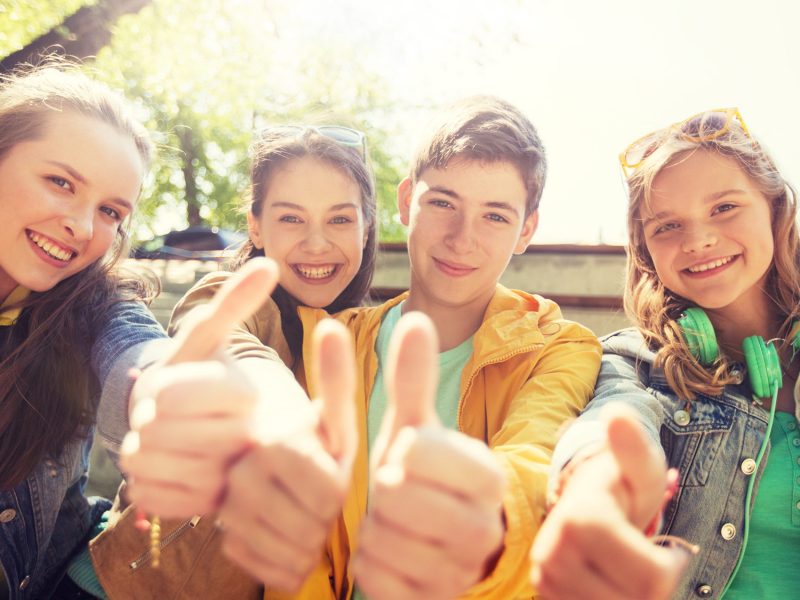 friendship, gesture and people concept - happy teenage friends or high school students showing thumbs up